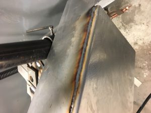 It is possible to get spatter free welds on galvanized  steel.  Developing and following a qualified welding procedure is the first step.